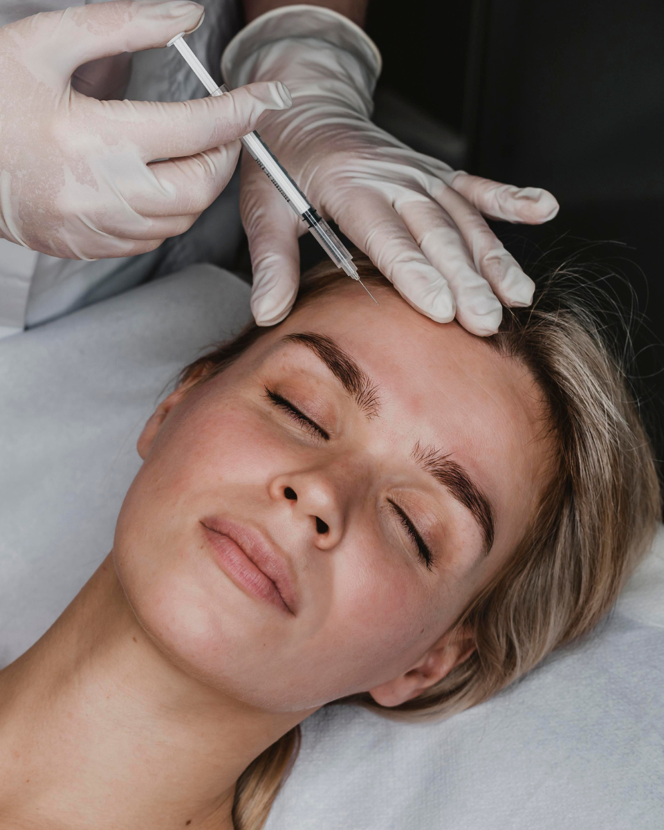 Profesional aplicando neuromoduladores en el tercio superior del rostro para relajar la musculatura y suavizar las arrugas de expresión